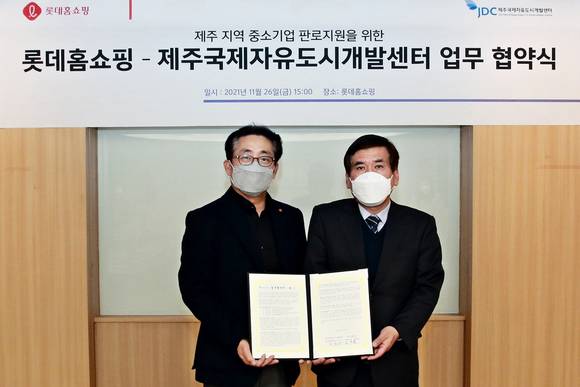 ▲김재겸 롯데홈쇼핑 지원본부장(왼쪽)과 강승수 제주국제자유도시개발센터(JDC) 경영기획본부장이 지난 26일 영등포구 양평동 롯데홈쇼핑 본사에서 업무협약을 맺은 뒤 기념촬영을 하고 있다. / 사진=롯데홈쇼핑