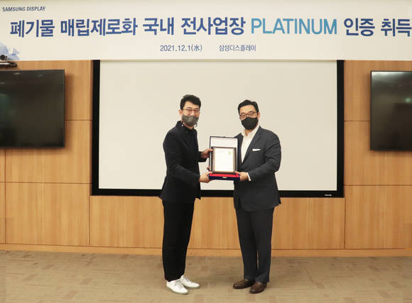 ▲최송천 삼성디스플레이 글로벌 인프라 총괄 전무(왼쪽)와 정륜 UL코리아 대표가 1일 폐기물 매립 제로 플래티넘 인증 수여식에서 기념촬영을 하고 있다. / 사진=삼성디스플레이