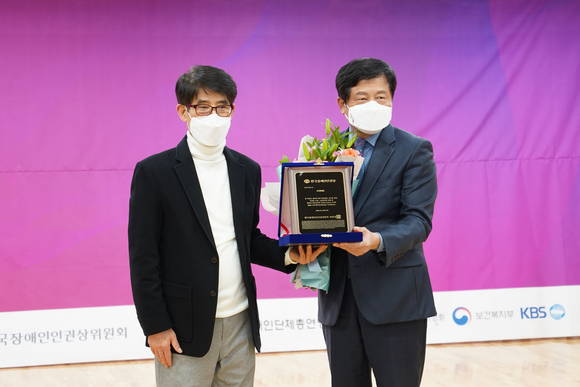▲박용주 SK텔레콤 ESG 담당(오른쪽)이 변승일 한국장애인단체총연맹 공동대표로부터 한국장애인인권상을 수상하고 있다. / 사진=SK텔레콤