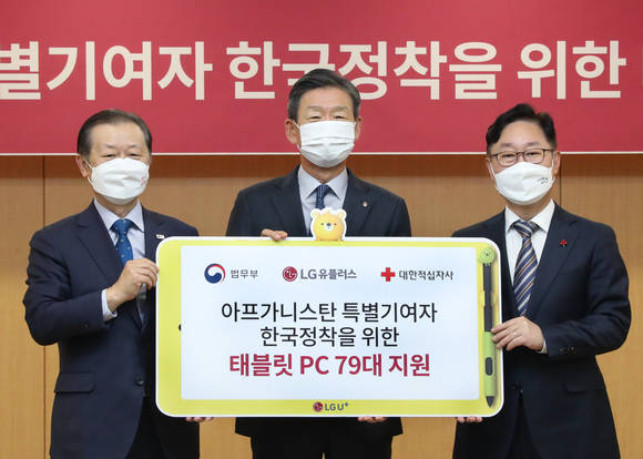 ▲(왼쪽부터) 신희영 대한적십자사 회장, 황현식 LG유플러스 사장, 박범계 법무부 장관이 한국에 체류 중인 아프가니스탄 특별기여자에게 인터넷과 초등나라 전용 패드 및 서비스를 제공하기 위한 ‘지원 물품 전달식’에서 기념촬영을 하고 있다. / 사진=LG유플러스