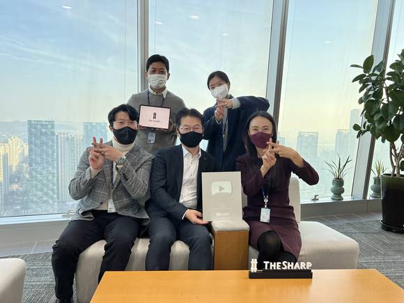 ▲포스코건설 건축사업본부 직원들이 더샵TV 구독자 10만 명 돌파 기념사진을 촬영하고 있다. / 사진=포스코건설