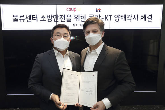 ▲송재호 KT AI/DX융합사업부문장과 라이언 브라운 쿠팡 환경보건안전 총괄 부사장이 물류센터 소방안전을 위한 양해각서를 체결한 뒤 기념촬영을 하고 있다. / 사진=KT