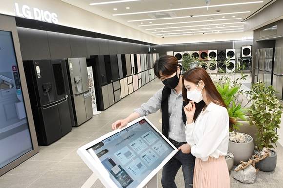 ▲LG전자 모델들이 무인매장에서 제품을 보고 있다. / 사진=LG전자