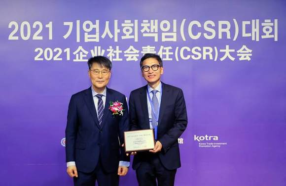 ▲두진우 메이뚜어식품 대표(오른쪽)가 지난 15일 중국 베이징 주중대한민국대사관에서 열린 ‘2021 기업사회책임(CSR) 대회’에서 장하성 주중대사로부터 수여받은 상패를 들고 기념촬영을 하고 있다. / 사진=풀무원