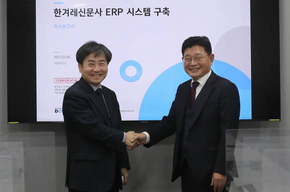 ▲김현대 한겨레신문사 대표(왼쪽)와 박원용 더존비즈온 부사장이 6일 한겨레신문사에서 열린 차세대 ERP 구축 및 개발 프로젝트 착수보고회에서 기념촬영을 하고 있다. / 사진=더존비즈온