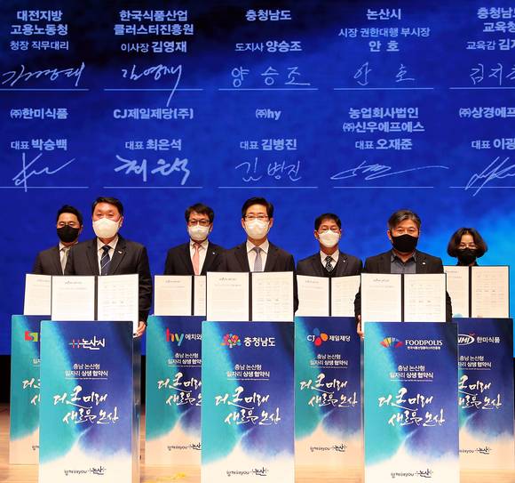 ▲김병진 hy 대표(뒷줄 왼쪽 세 번째)가 27일 오전 논산아트센터에서 지역 식품산업 발전과 고용확대를 위해 22개 유관기관과 업무협약을 체결하고 있다. / 사진=hy