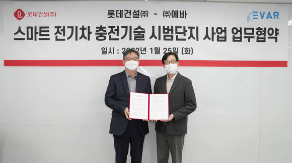 ▲박순전 롯데건설 기술연구원장(왼쪽)과 이훈 에바 대표가 스마트 전기차 충전기술 시범단지 사업 업무협약을 체결한 뒤 기념촬영을 하고 있다. / 사진=롯데건설