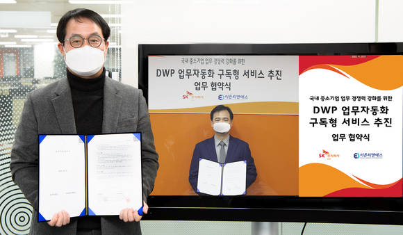 ▲이상국 SK㈜ C&C ICT 디지털부문장(왼쪽)과 김연기 이든티앤에스 대표가 ‘RPA 구독형 서비스 공동 사업 협력 업무협약’을 체결한 뒤 기념촬영을 하고 있다. / 사진=SK㈜ C&C