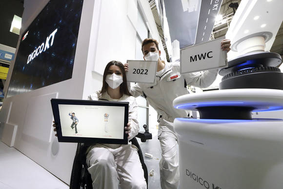 ▲KT가 ‘MWC 2022’에서 '디지털혁신의 엔진, DIGICO KT'를 주제로 전시관을 선보인다. 현지 도우미들이 KT 전시관에서 AI 방역로봇, 리얼댄스, AIoT 전동 휠체어 등 KT의 AI, 로봇 서비스를 소개하고 있다. / 사진=KT