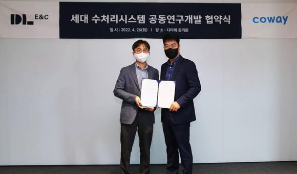 ▲지난 26일 서울 종로구 D타워 돈의문에 위치한 DL이앤씨 본사에서 열린 ‘세대 수처리시스템 공동연구 및 개발을 위한 업무협약식’에서 최양락 DL이앤씨 주택기술개발 담당 임원(왼쪽)과 박준현 코웨이 법인사업실장이 기념 사진을 찍고 있다. / 사진=DL이앤씨