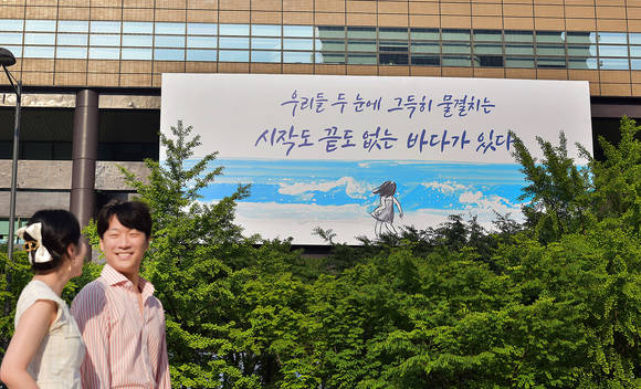 ▲30일 시민들이 교보생명 광화문글판 '여름편'이 내걸린 광화문 교보생명빌딩 주변을 걷고 있다. / 사진=교보생명
