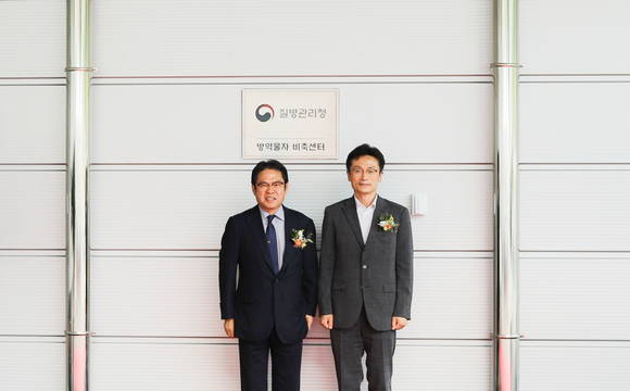 ▲오병진 한컴라이프케어 대표(왼쪽)와 김헌주 질병관리청 차장이 1일 경기도 용인시 한컴라이프케어 사옥에서 열린 방역물자 비축센터 개소식에 참석해 기념촬영을 하고 있다. / 사진=한컴라이프케어