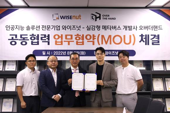 ▲강용성 와이즈넛 대표(왼쪽 세 번째)와 이규승 오버더핸드 대표(두 번째)가 메타버스 플랫폼 내 광고사업 협력을 위한 양해각서를 체결한 뒤 기념촬영을 하고 있다. / 사진=와이즈넛