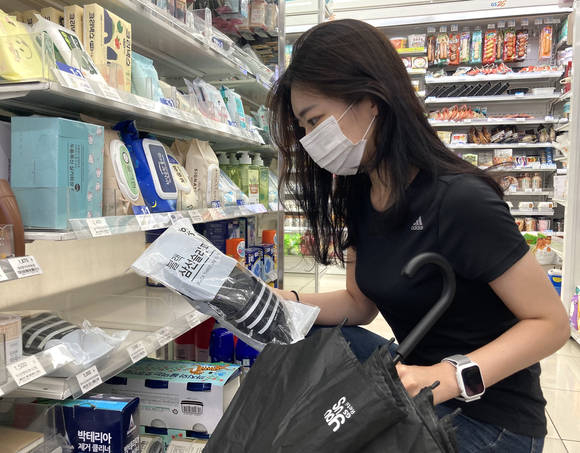 ▲비가 내리자 고객이 GS25에서 유어스 슬리퍼를 구매하고 있다. / 사진=GS리테일