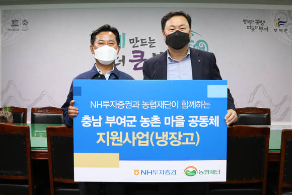 ▲심기필 NH투자증권 경영지원본부장(오른쪽)과 박정현 부여군수가 냉장고 전달식에서 기념촬영을 하고 있다. / 사진=NH투자증권