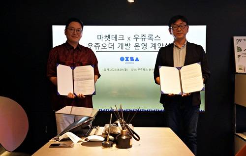 ▲(왼쪽부터) 박누남 우쥬록스 대표와 박승준 마켓테크 대표가 우쥬오더 개발 및 운영에 대한 계약을 체결한 후 기념촬영을 하고 있다. / 사진=우쥬록스