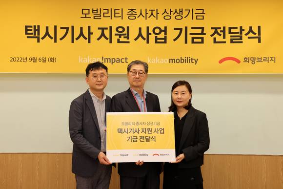 ▲김수 카카오모빌리티 정책협력실장(왼쪽 첫 번째), 송필호 희망브리지 전국재해구호협회 회장(두 번째), 육심나 카카오 ESG 부사장(세 번째)이 지난 6일 택시기사 지원사업 기금 전달식에서 기념촬영을 하고 있다. / 사진=카카오모빌리티