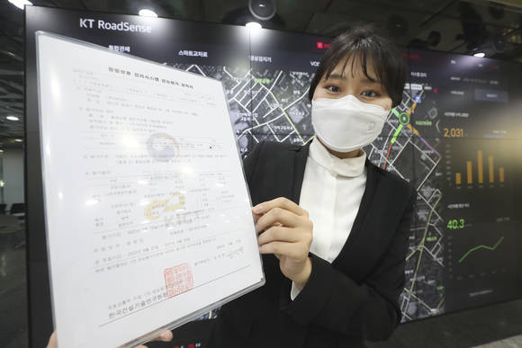 ▲KT가 개발한 교통디지털전환(DX) 솔루션 ‘로드센스(RoadSense)’가 한국건설기술연구원의 지능형교통체계(ITS) 돌발상황검지 성능평가에서 최고 등급을 받았다. KT 관계자가 로드센스 솔루션의 ITS 성능평가 성적서를 들고 기념촬영을 하고 있다. / 사진=KT