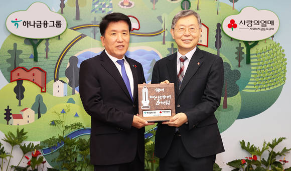 ▲함영주 하나금융그룹 회장(왼쪽)이 조흥식 사회복지공동모금회 회장에게 연말 이웃돕기 성금 150억 원을 전달하고 함께 기념촬영을 하고 있다. / 사진=하나금융그룹