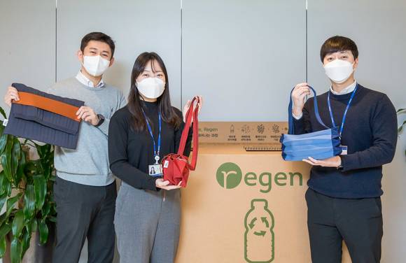 ▲효성티앤씨 직원들이 사내 페트병 수거함 앞에서 친환경 섬유 리젠으로 만든 가방을 선보이고 있다. / 사진=효성