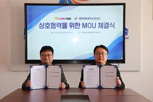 ▲이선우 캔디코드 이사(좌측)와 왕도 위해시과학기술서비스업협회 회장이 업무협약 체결식에서 기념 촬영을 하고 있다. / 사진=캔디코드