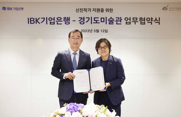 ▲문창환 IBK기업은행 경영전략그룹장(왼쪽)과 안미희 경기도미술관장이 서울 을지로 기업은행 본점에서 열린 ‘신진작가 지원을 위한 IBK기업은행-경기도미술관 업무협약식‘에서 기념촬영을 하고 있다. / 사진=IBK기업은행