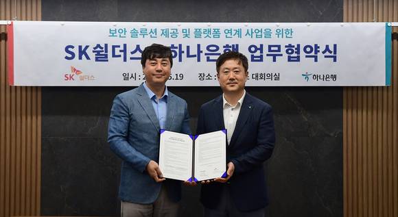 ▲김윤호 SK쉴더스 성장추진실장(왼쪽)과 하나은행 이동현 기업사업본부장이 보안 솔루션 제공 및 플랫폼 연계 사업을 위한 업무협약식에서 기념촬영을 하고 있다. / 사진=SK쉴더스
