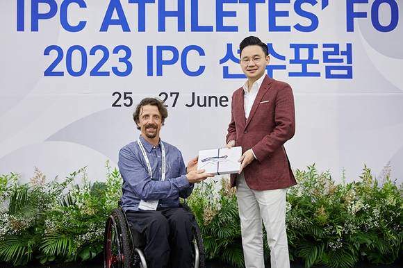 ▲배동현 이사장이 환영만찬장에서 전 세계 참가선수들을 위해 준비한 기념품을 조쉬두엑 IPC 선수위원회 부위원장에게 전달했다.
