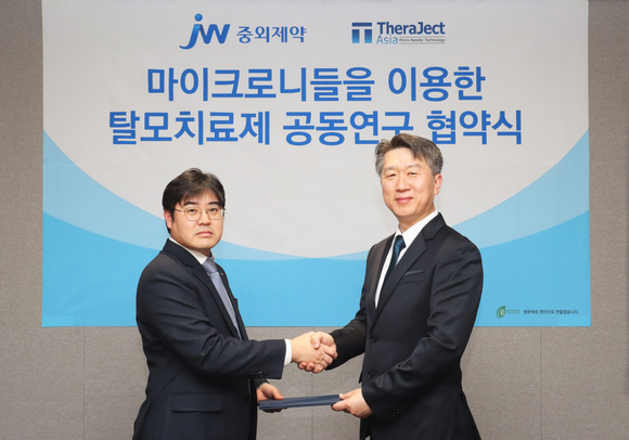 ▲진세호 JW중외제약 제제연구센터장(왼쪽)과 김경동 테라젝아시아 대표가 협약을 체결한 뒤 기념사진을 촬영하고 있다 / 사진=JW중외제약