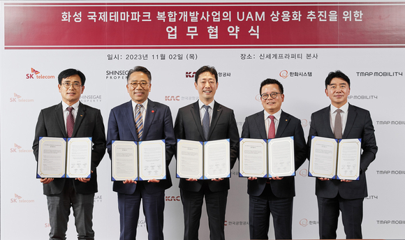 ▲(왼쪽부터)신용식 SK텔레콤 부사장, 임영록 신세계프라퍼티 대표이사, 윤형중 한국공항공사 사장, 어성철 한화시스템 대표이사, 이종호 티맵모빌리티 대표이사가 2일 역삼동 신세계프라퍼티 본사에서 업무협약을 체결한 뒤 기념촬영을 하고 있다. / 사진=SK텔레콤 K-UAM드림팀, 신세계프라퍼티와 UAM 활용한 미래 모빌리티 허브 구축 나선다