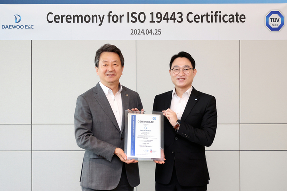 ▲25일 대우건설 본사에서 열린 ISO 19443 인증서 수여식에 참석한 백정완 대우건설 대표이사(왼쪽)와 서정욱 티유브이 슈드 코리아(TÜV SÜD Korea) 대표이사가 기념촬영을 하고 있다. / 사진=대우건설
