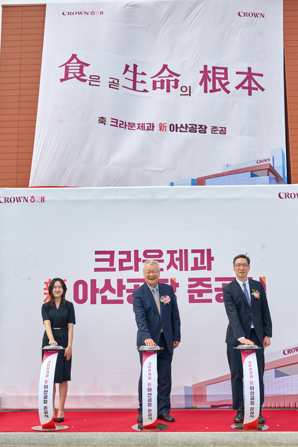 ▲윤영달 크라운해태제과 회장(왼쪽 두 번째)과 윤석빈 크라운제과 대표(세 번째), 신입사원 손유리 사원(첫 번째)이 4월 30일 크라운제과 신 아산공장 제막식 행사를 하고 있다. / 사진=크라운제과 크라운제과, 생산능력 두 배 늘린 ‘신 아산공장’ 준공