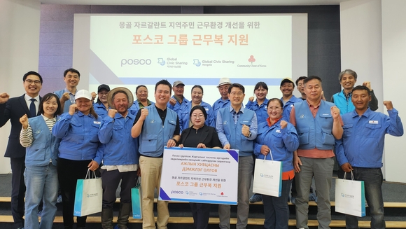 ▲포스코 노사 관계자들이 몽골 자르갈란트 지역 목축농가 주민들에게 포스코 구형 근무복을 전달한 후 기념사진을 찍고 있다. / 사진=포스코