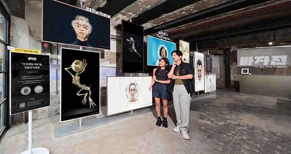 ▲삼성전자 모델이 '바자展: UNDER/STAND with 삼성 The Frame'에서 라이프스타일 TV 삼성 '더 프레임'을 활용한 10M 길이의 대형 아트 월을 체험하고 있다. / 사진=삼성전자 삼성. 더 프레임으로 현대미술 작품 전시