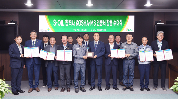 ▲홍승표 에쓰오일 CSO(앞줄 왼쪽에서 다섯번째), 이동은 구매부문장(앞줄 왼쪽에서 첫번째), 김경태 정비부문장(앞줄 왼쪽에서 여덟번째)가 수여식을 마치고, 공흥두 안전보건공단 부산광역본부장과(앞줄 왼쪽에서 여섯번째) 및 10개 협력사 대표들과 기념촬영을 하고 있다. / 사진=에쓰오일 에쓰오일, 33개 협력사 안전사업장 인증 지원