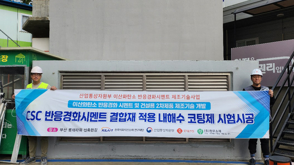▲롯데건설 직원들이 부산 롯데타워 현장에서 이산화탄소 반응경화 시멘트를 활용한 코팅제를 시공하고 기념촬영을 하고 있다. / 사진=롯데건설 롯데건설, 이산화탄소 배출 저감 시멘트 현장적용