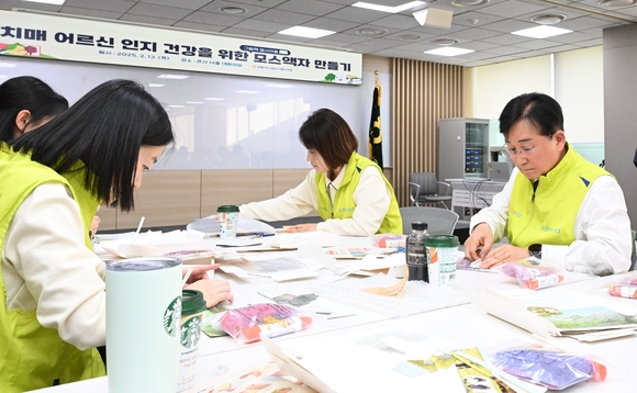 ▲송춘수 대표이사(사진 오른쪽)를 비롯한 ‘헤아림 봉사단’이 공기정화액자를 만들고 있다. / 사진=NH농협손보 NH농협손보, 치매안심센터에 공기정화액자 300개 전달