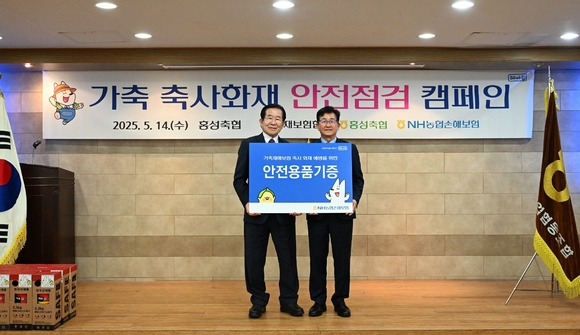 ▲송춘수 NH농협손보 대표이사(오른쪽)가 이대영 홍성축협 조합장에게 14일 충남 홍성축산농협에서 화재예방 안전용품 기증 후 기념촬영을 하고 있다. / 사진=NH농협손보 NH농협손보, 축사 화재 안전점검 캠페인 실시