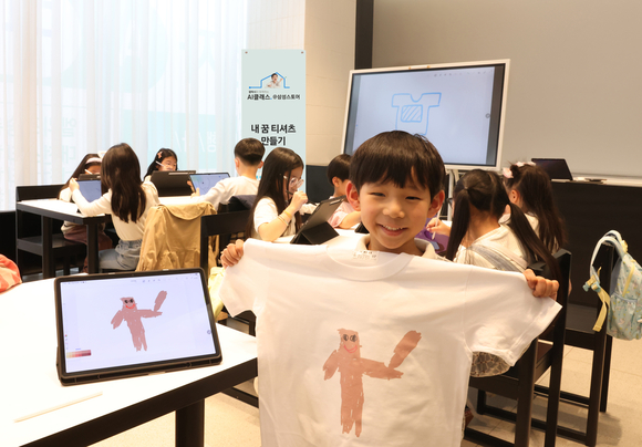 ▲삼성스토어 대전에서 진행된 '갤럭시와 함께하는 AI 클래스(삼성스토어)'에서 아이들이 갤럭시 AI를 활용해 만든 티셔츠와 기념 촬영을 하는 모습 / 사진=삼성전자 삼성전자, 학생 대상 AI 체험 프로그램 갤럭시와 함께하는 AI 클래스 운영