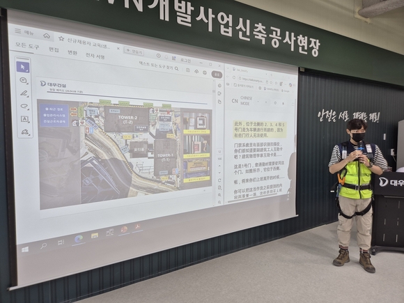 ▲대우건설 관계자가 과천 G-TOWN 개발사업 현장에서 외국인 근로자를 위한 AI 번역기 기능에 대해 교육 중이다. / 사진=대우건설 대우건설, 건설현장 맞춤형 실시간 AI 번역기 개발